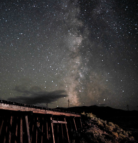 The Milky Way rising over an old wooden trestle